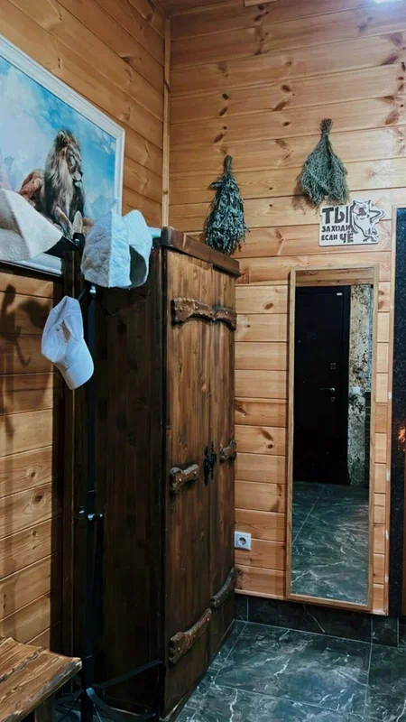 Предбанник с вешалками и вениками